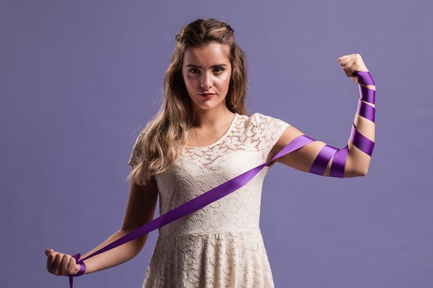 Mujer flexionando su brazo con cinta como un signo de fuerza