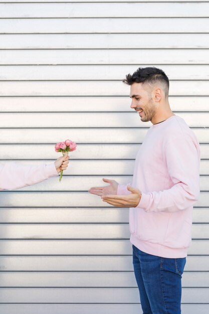 Mujer con flores cerca de hombre feliz