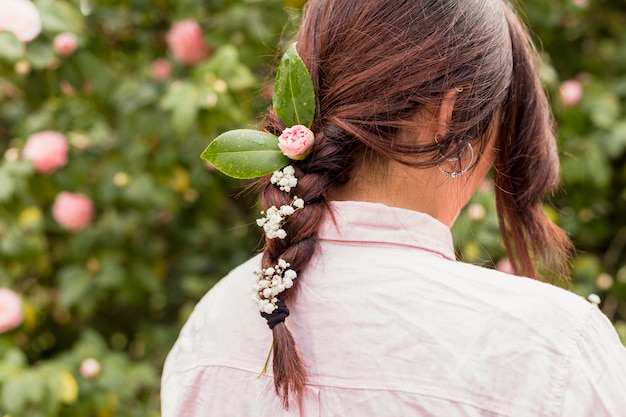 Foto gratuita mujer con flores y hojas en peinado.