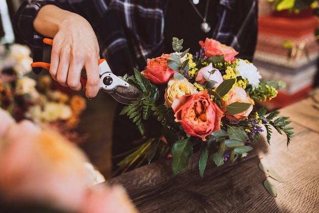 Mujer florista en su propia tienda de flores cuidando flores