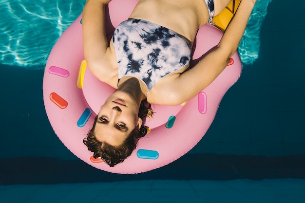 Foto gratuita mujer en flotador rosa en piscina