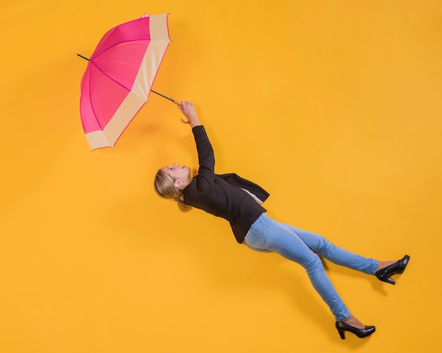 Mujer flotando en el aire con un paraguas