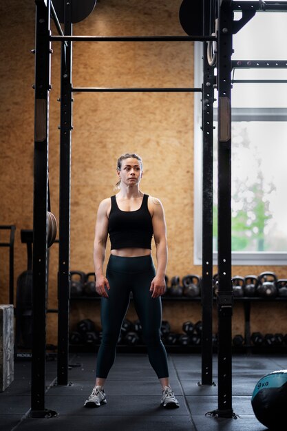 Mujer en forma de disparo completo entrenando en el gimnasio