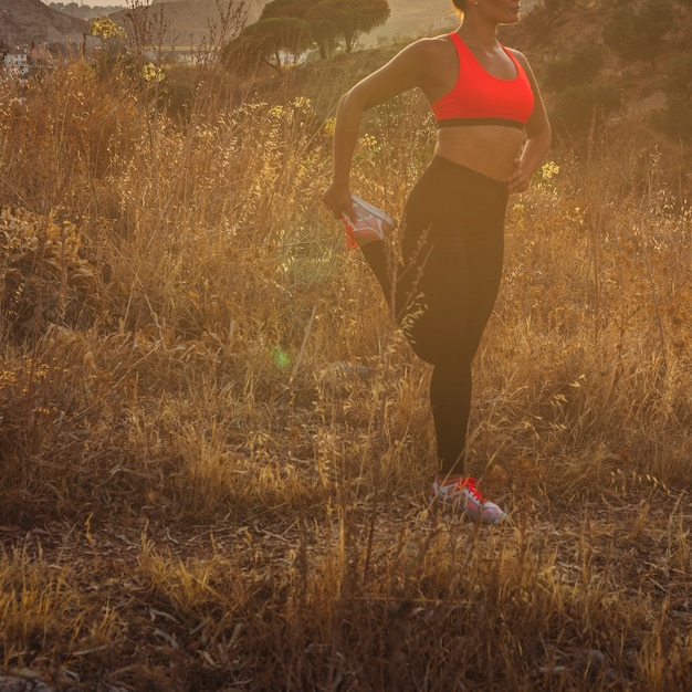 Foto gratuita mujer en forma estirando en el campo