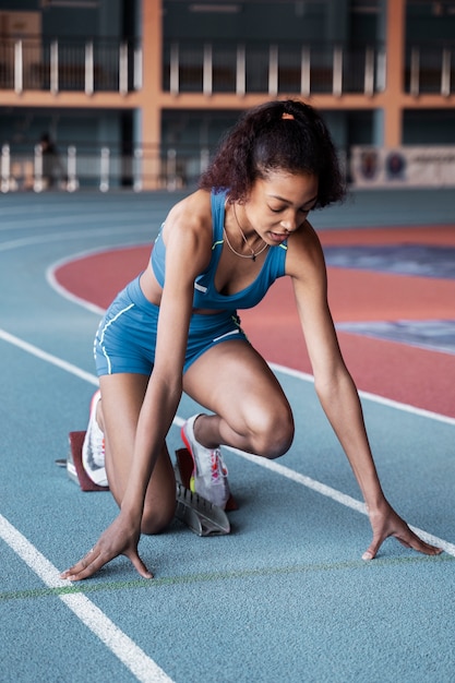 Mujer en forma en la línea de salida de tiro completo