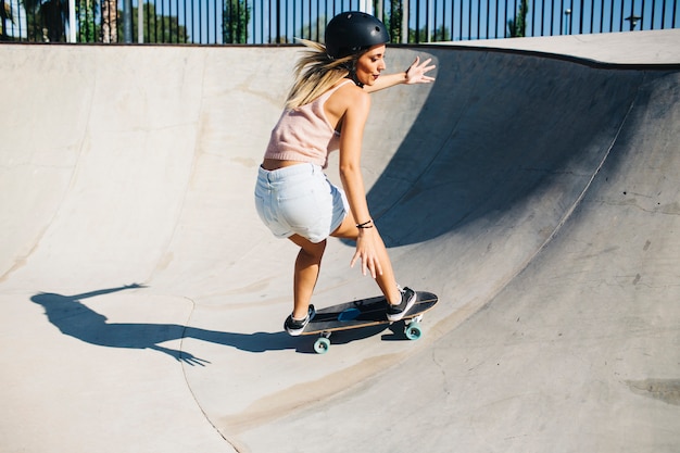 Mujer en forma con patineta y casco