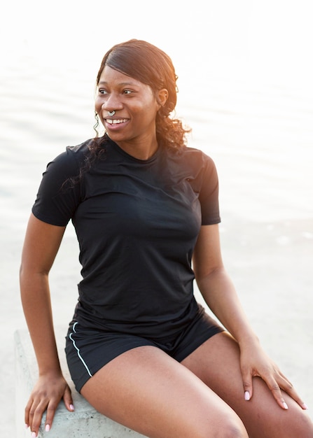 Foto gratuita mujer en forma sonriente posando al aire libre