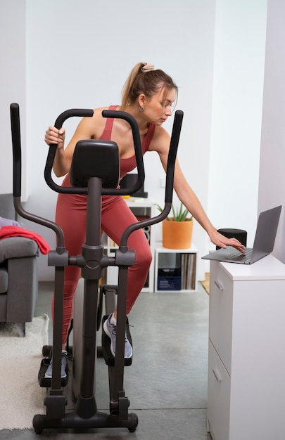 Mujer en forma de tiro completo en bicicleta estática