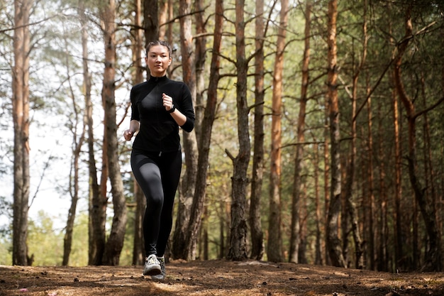 Mujer en forma de tiro completo corriendo al aire libre