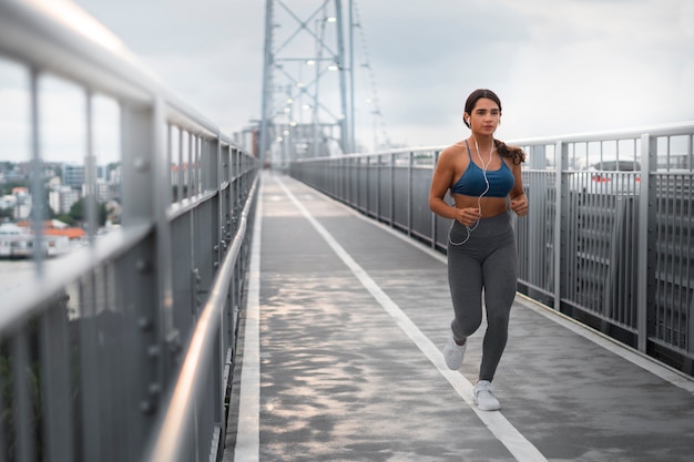 Foto gratuita mujer en forma de tiro completo corriendo al aire libre