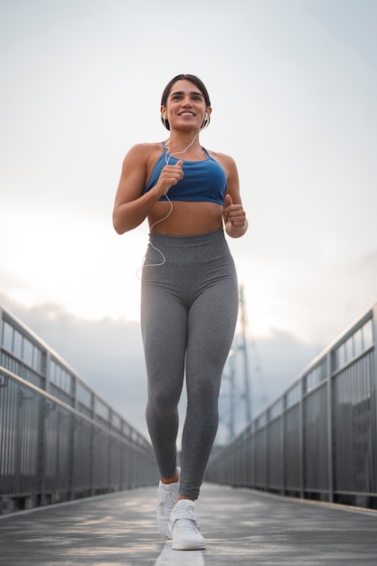 Mujer en forma de tiro completo corriendo al aire libre