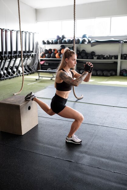 Mujer en forma de tiro completo entrenando en el gimnasio