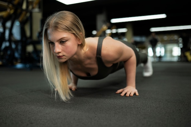 Mujer en forma de tiro completo entrenando en el gimnasio