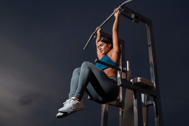 Mujer en forma de tiro completo entrenando con máquina