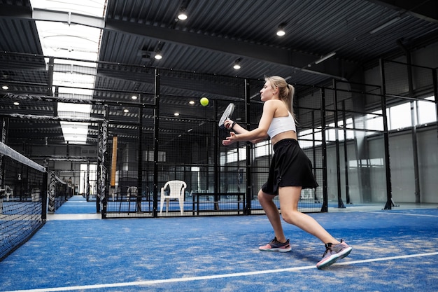 Mujer en forma de tiro completo jugando al pádel