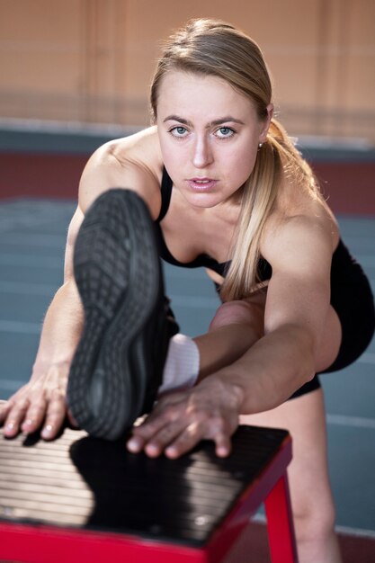 Mujer en forma de tiro medio estirando la pierna