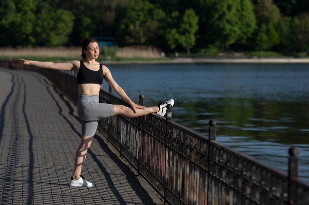 Foto gratuita mujer en forma de vista lateral que se extiende en la naturaleza