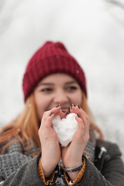 Foto gratuita mujer formando nieve en corazón