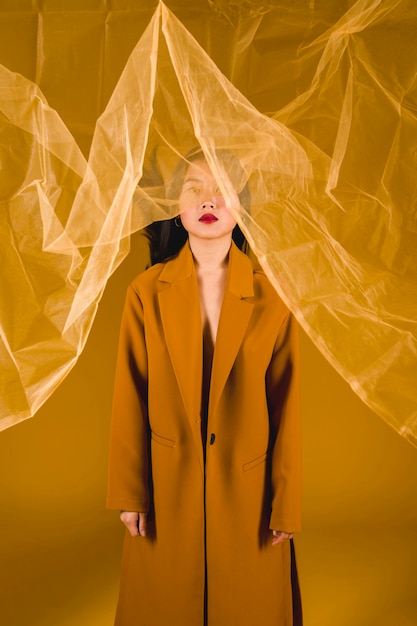 Mujer fotogénica en abrigo amarillo.