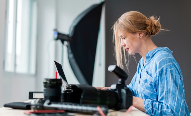 Mujer fotógrafo lateralmente trabajando en su banco