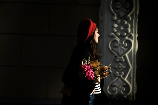 Mujer francesa con baguettes en la calle en beret