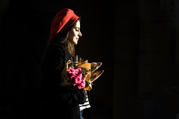 Mujer francesa con baguettes en la calle en beret