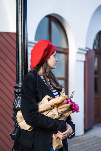 Foto gratuita mujer francesa con baguettes en la calle en beret