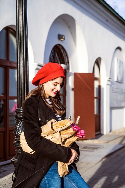 Mujer francesa con baguettes en la calle en beret