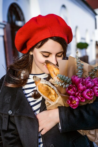 Mujer francesa con baguettes en la calle en beret