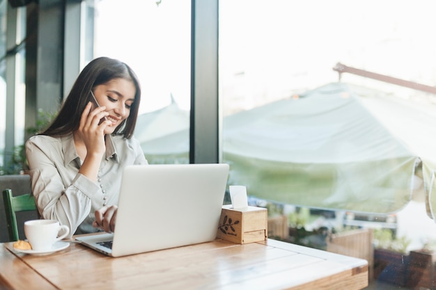 Foto gratuita mujer freelance trabajando con portátil en cafetería