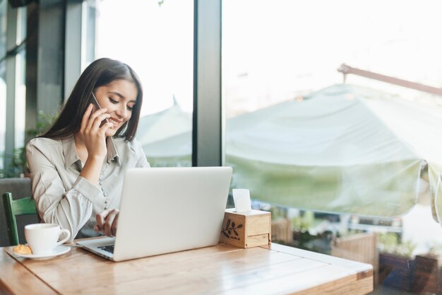 Mujer freelance trabajando con portátil en cafetería