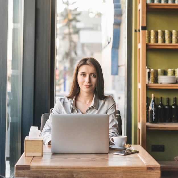 Mujer freelance trabajando con portátil en cafetería