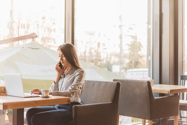 Mujer freelance trabajando con portátil en cafetería