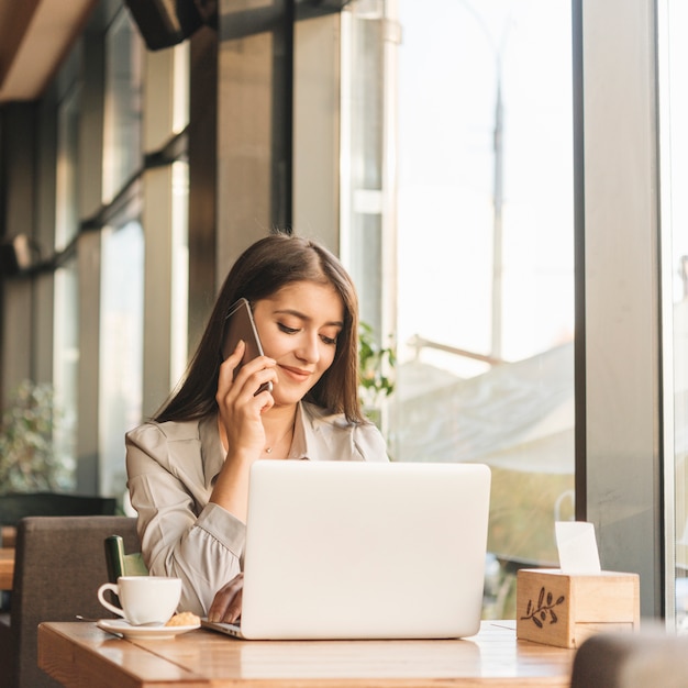 Foto gratuita mujer freelance trabajando con portátil en cafetería