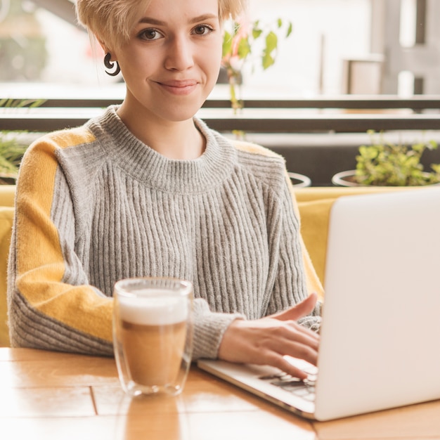 Mujer freelance trabajando con portátil en cafetería