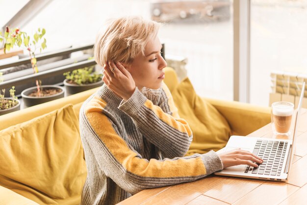 Mujer freelance trabajando con portátil en cafetería