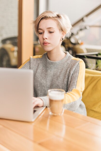 Mujer freelance trabajando con portátil en cafetería