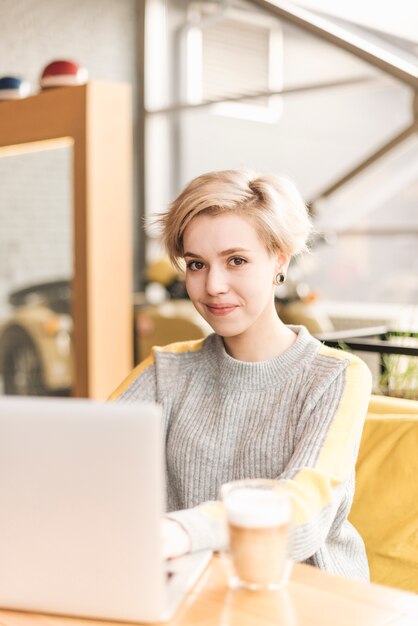 Mujer freelance trabajando con portátil en cafetería