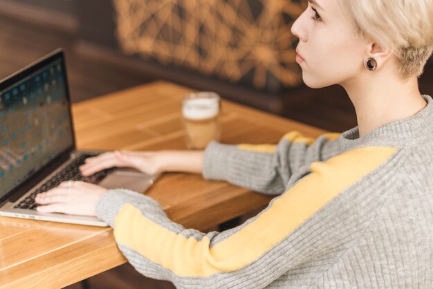 Mujer freelance trabajando con portátil en cafetería