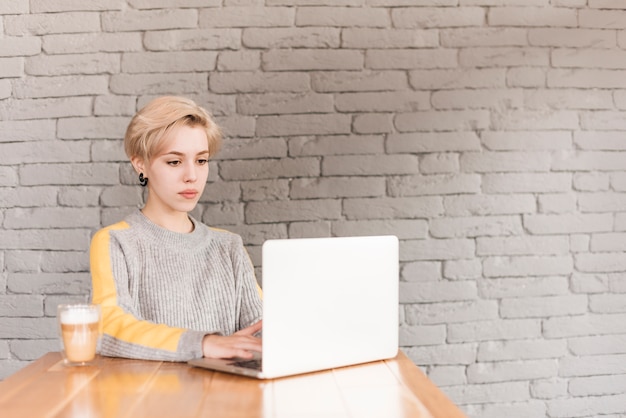 Mujer freelance trabajando con portátil en cafetería