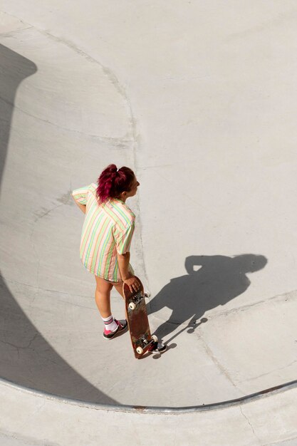 Mujer fresca de tiro completo en patineta