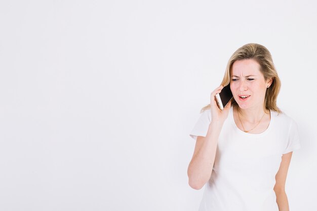 Mujer frunciendo el ceño hablando por teléfono