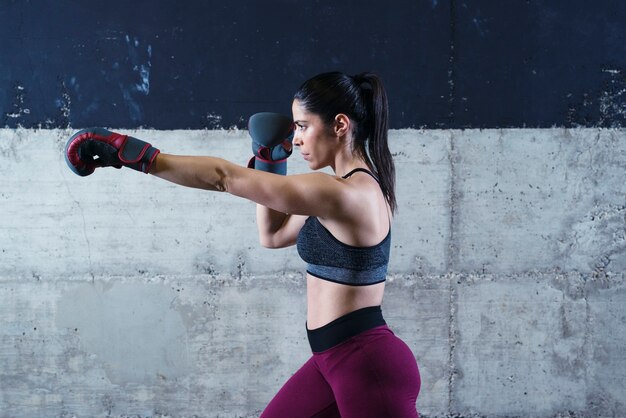 Mujer fuerte fitness sexy en entrenamiento de boxeo