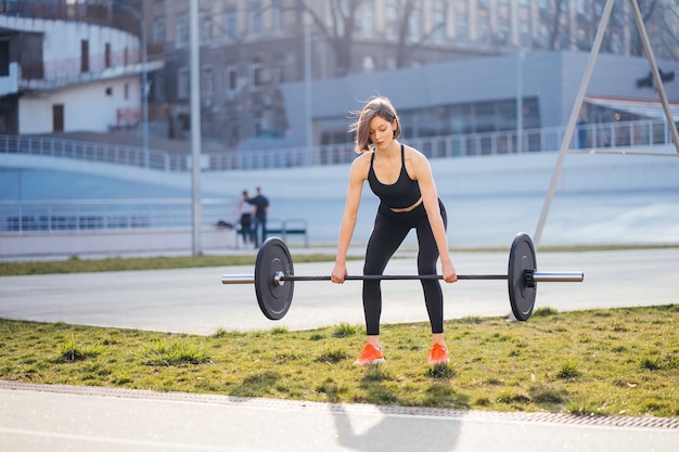 Mujer fuerte haciendo ejercicio con el concepto de fitness deportes con barra