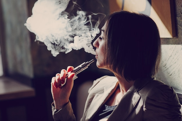 Foto gratuita mujer fumando vapor