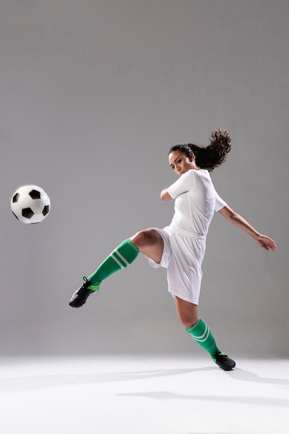 Foto gratuita mujer de fútbol pateando fútbol