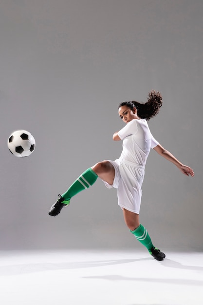 Mujer de fútbol pateando fútbol