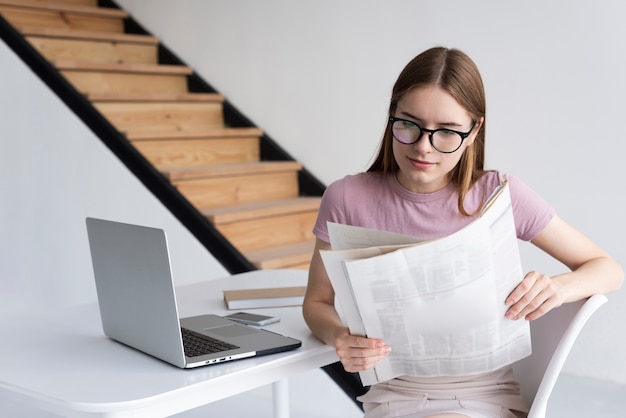 Foto gratuita mujer con gafas leyendo el periódico