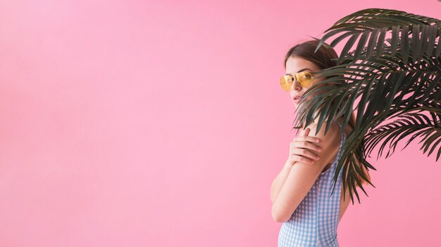 Foto gratuita mujer con gafas de sol enfrente de palmera