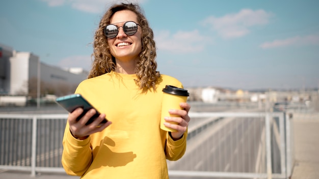 Foto gratuita mujer con gafas de sol con una taza de café